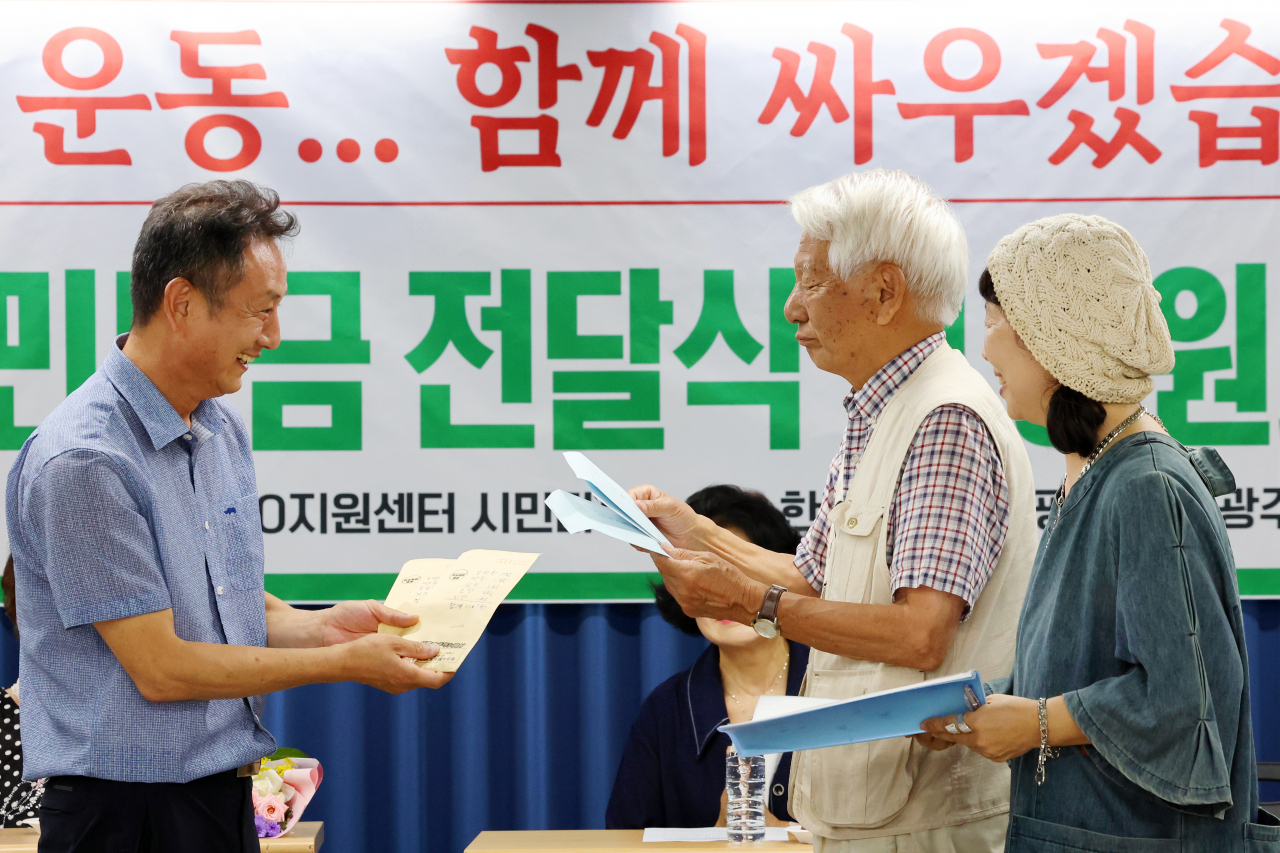 14일 오후 광주 동구 전일빌딩245 4층 시민마루에서 열린 한일역사정의평화행동·광주전남역사지킴이의 시민모금 전달식에서 이국언 일제강제동원시민모임 이사장이 일본 시민단체 '나고야 미쓰비시 조선여자근로정신대 소송을 지원하는 모임' 다카하시 마코토 대표로부터 성금을 전달받고 있다.[연합]
