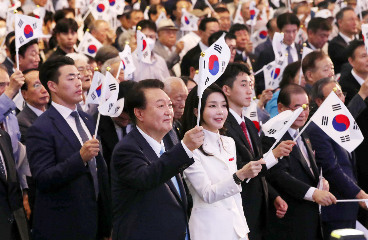윤석열 대통령과 김건희 여사가 15일 서울 서대문구 이화여대 대강당에서 열린 제78주년 광복절 경축식에서 만세삼창을 한 뒤 태극기를 흔들고 있다. [연합]