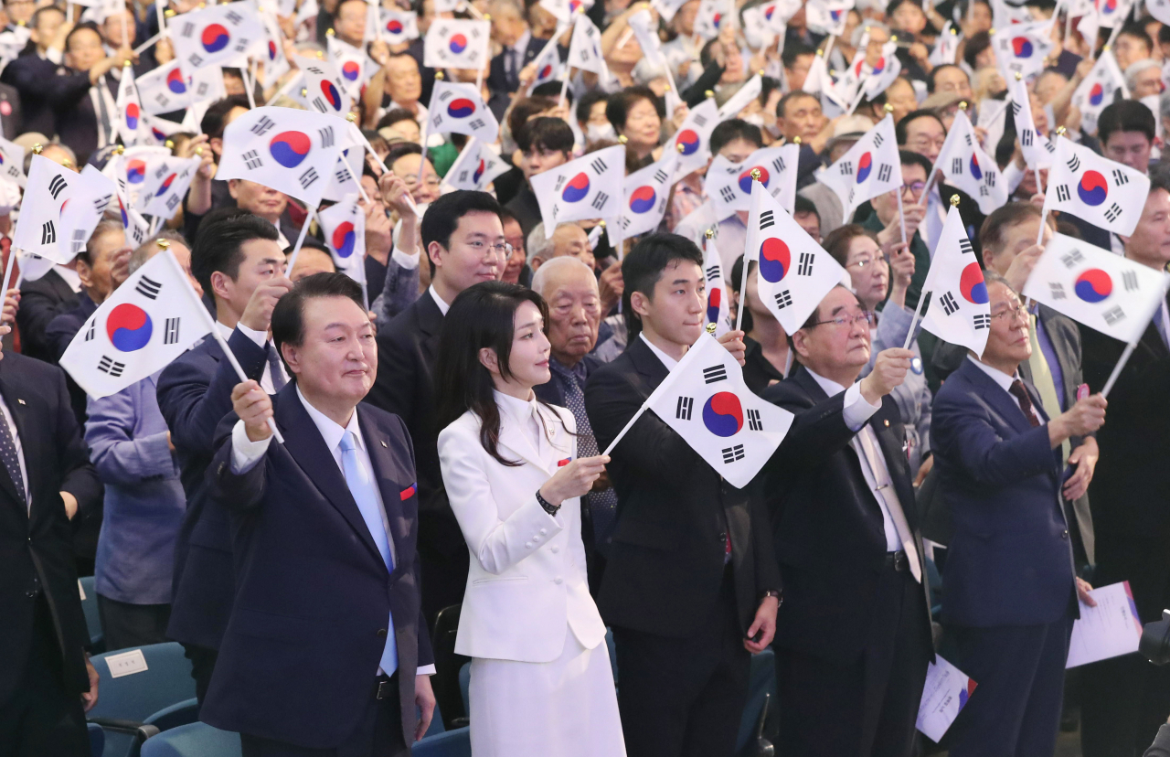 윤석열 대통령과 김건희 여사가 15일 서울 서대문구 이화여대 대강당에서 열린 제78주년 광복절 경축식에서 만세삼창을 한 뒤 태극기를 흔들고 있다. [연합]