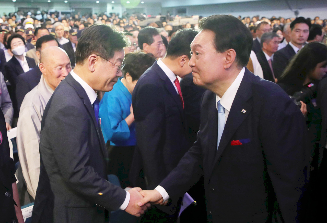 윤석열 대통령이 15일 서울 서대문구 이화여대 대강당에서 열린 제78주년 광복절 경축식에서 퇴장하며 더불어민주당 이재명 대표와 악수하고 있다. [연합]