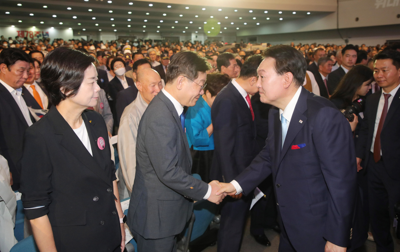 윤석열 대통령이 15일 서울 서대문구 이화여대 대강당에서 열린 제78주년 광복절 경축식에서 퇴장하며 이재명 더불어민주당 대표와 악수하고 있다. [연합]