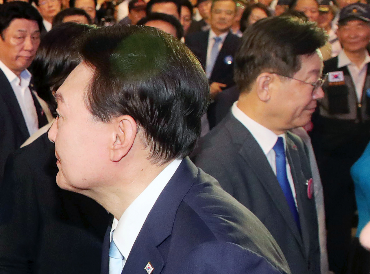 윤석열 대통령이 15일 서울 서대문구 이화여대 대강당에서 열린 제78주년 광복절 경축식에서 퇴장하며 이재명 더불어민주당 대표 앞을 지나고 있다. [연합]