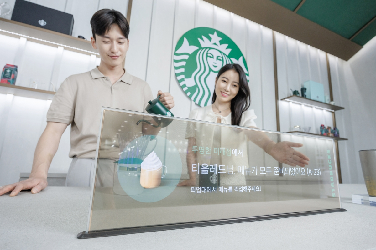 16일 서울 코엑스에서 열린 ‘K디스플레이 2023’ 전시회에서 LG디스플레이 모델이 스타벅스와 협업한 매장용 투명 OLED 콘셉트를 소개하고 있다. [LG디스플레이 제공]