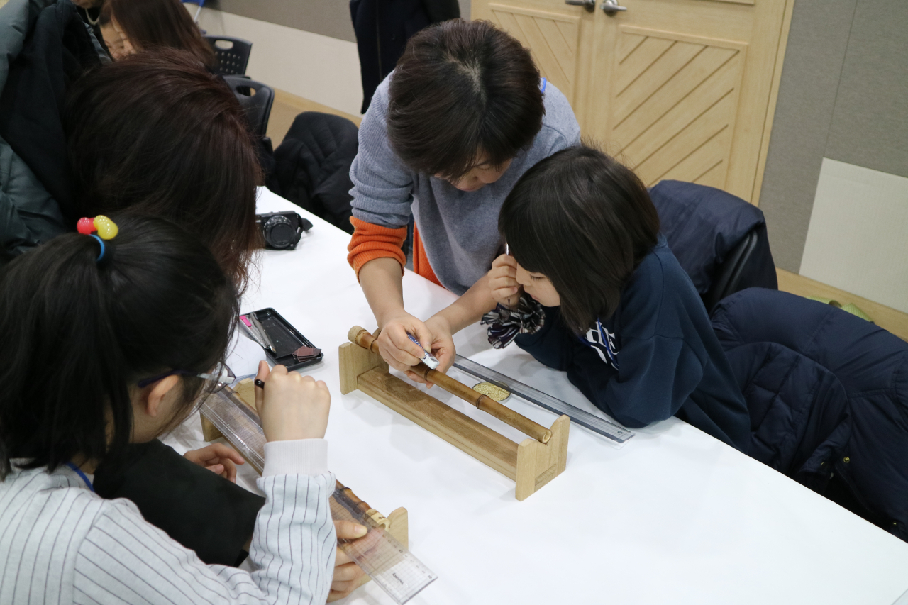 Children participating in a crafting class make "danso," a traditional woodwind instrument. (National Gugak Center)