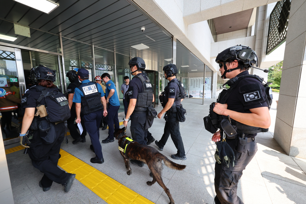 Police special operation units and sniffer dogs search the city hall in Incheon, west of Seoul, after email bomb threats were received nationwide on Wednesday. (Yonhap)