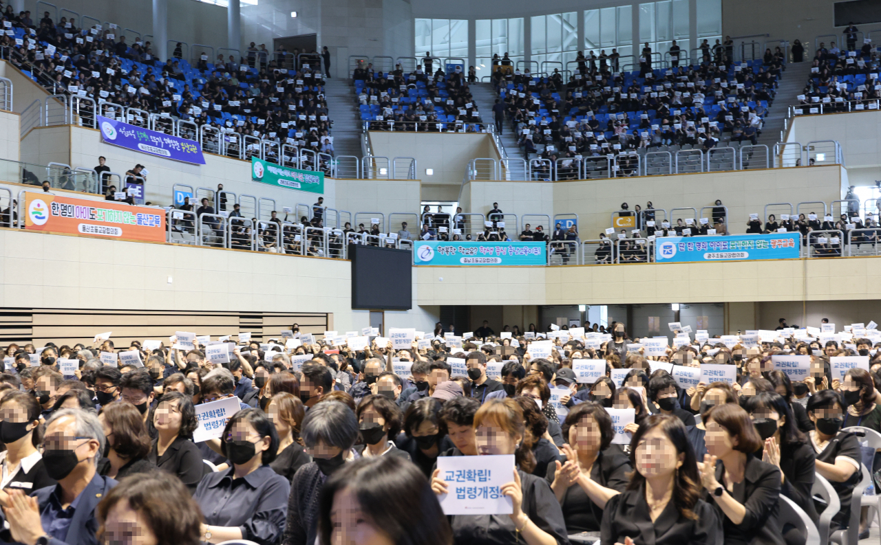 이주호 사회부총리 겸 교육부장관이 17일 오후 충북 청주시 청원구 내덕동 청주대학교에서 열린 제62회 한국초등교장협의회 하계연수회에서 발언하고 있는 가운데 참석자들이 피켓을 들어 보이며 구호를 외치고 있다. [연합]