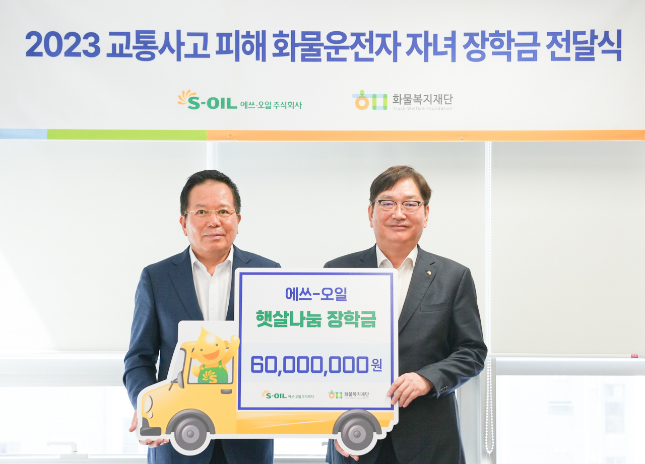 서정규(오른쪽) S-OIL 국내영업본부장이 최광식 화물복지재단 이사장과 교통사고 피해 화물차 운전자 자녀를 위한 장학금 전달식을 열고 기념촬영을 하고 있다. [S-OIL 제공]