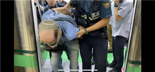 19일 서울 지하철 2호선 열차 안에서 열쇠고리에 붙은 쇠붙이로 승객들을 공격하며 난동을 부린 남성이 경찰에 체포되고 있다. [연합]