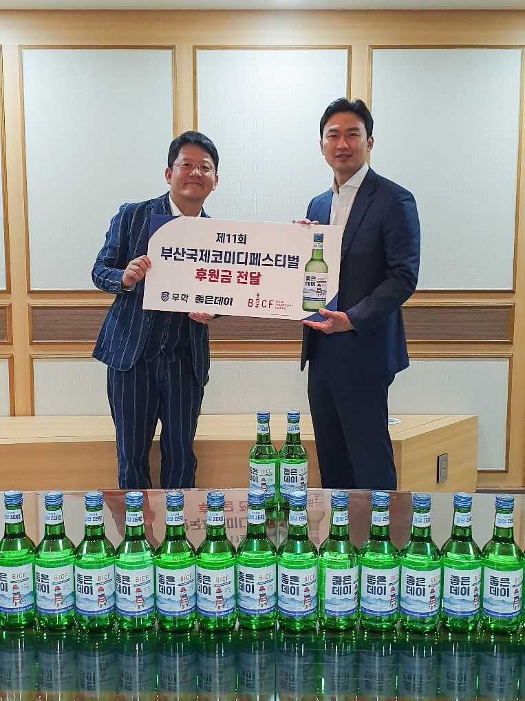 최낙준 무학 사장(오른쪽)이 21일 무학 서울지점에서 김준호 부산국제코미디페스티벌 조직위원장에게 축제 후원금 3000만원을 전달하고 있다. [사진=무학]