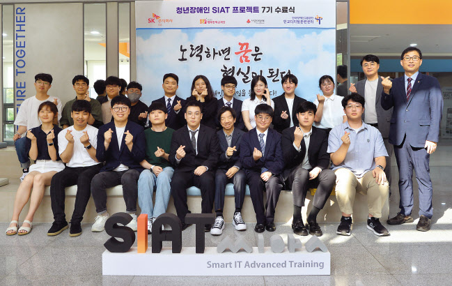 김성한(뒷줄 오른쪽 두번째) SK(주) C&C ESG담당과 최영수 판교디지털훈련센터 센터장(뒷줄 오른쪽 첫번째)이 청년 장애인 IT 전문가 육성 프로그램 ‘씨앗’(SIAT) 7기 수료식에서 수료생과 기념 촬영을 하고 있다. [SK(주) C&C 제공]