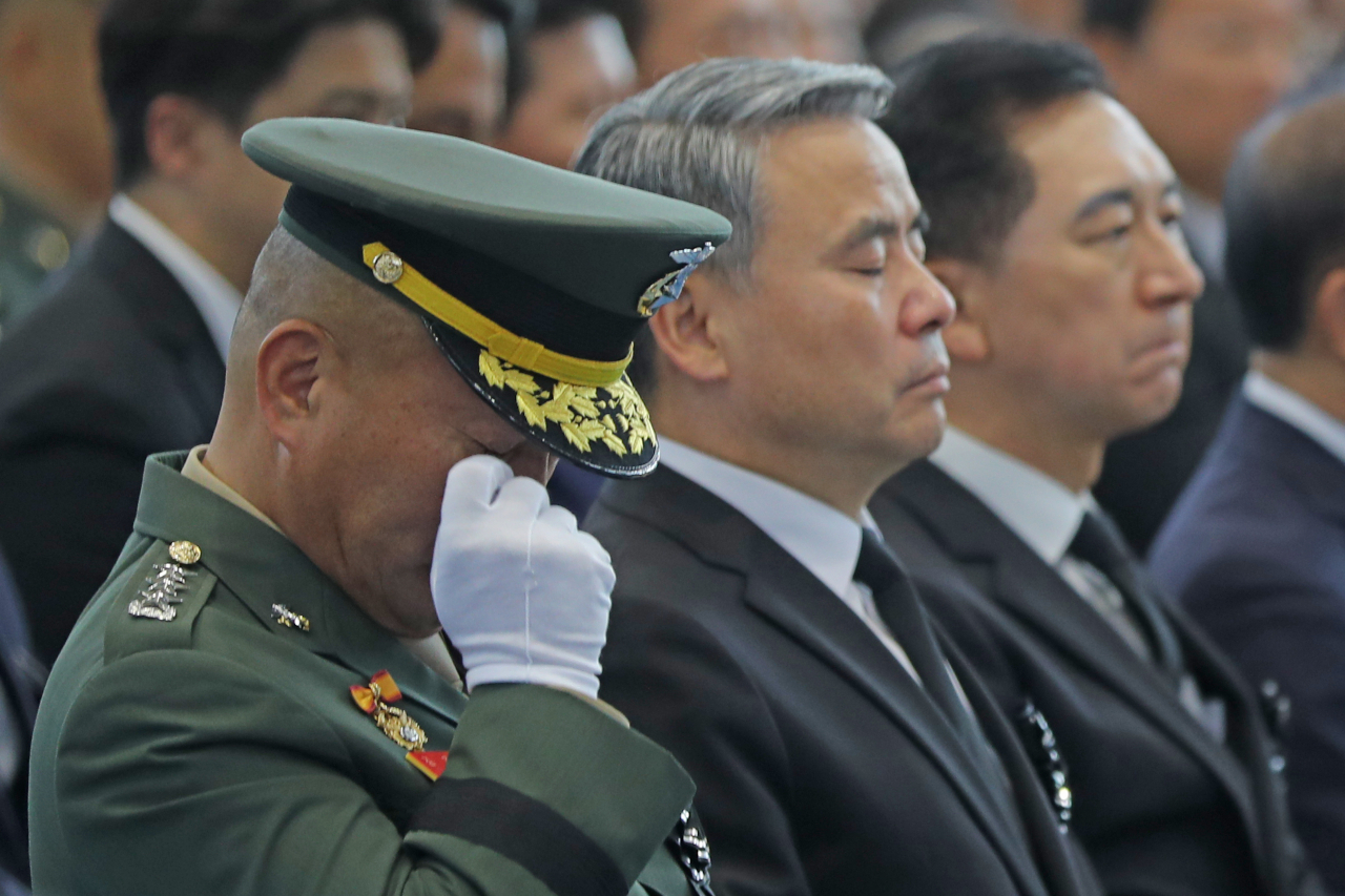 지난달 22일 경북 포항 해병대 1사단 체육관에서 열린 채 상병 영결식에서 이종섭 국방부 장관(가운데) 옆에 자리한 김계환 해병대 사령관(왼쪽)이 눈물을 닦고 있다. [연합]