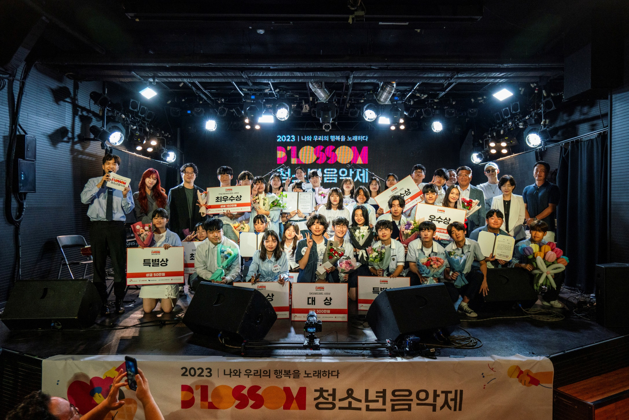 SK브로드밴드를 비롯한 주최사 관계자들이 지난 19일 서울 마포구 롤링홀에서 열린 ‘2023 블러썸 청소년 음악제’ 시상식에서 수상자들과 기념 촬영하고 있다. [SK브로드밴드 제공]