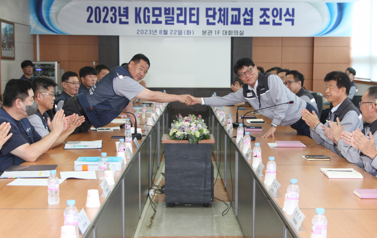 정용원 KG 모빌리티 대표이사(오른쪽)와 선목래 노동조합 위원장이 2023 임단협 합의안에 서명 후 기념 촬영을 하고 있다. [KG 모빌리티 제공]