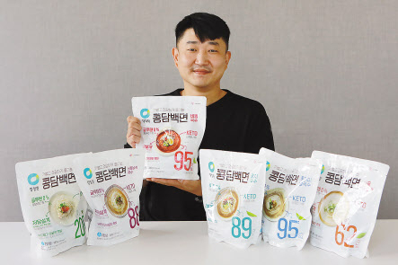 김용건 대상 식품연구소 수석연구원이 본인이 개발한 콩담백면 제품들과 함께 환하게 미소짓고 있다. [대상 제공]