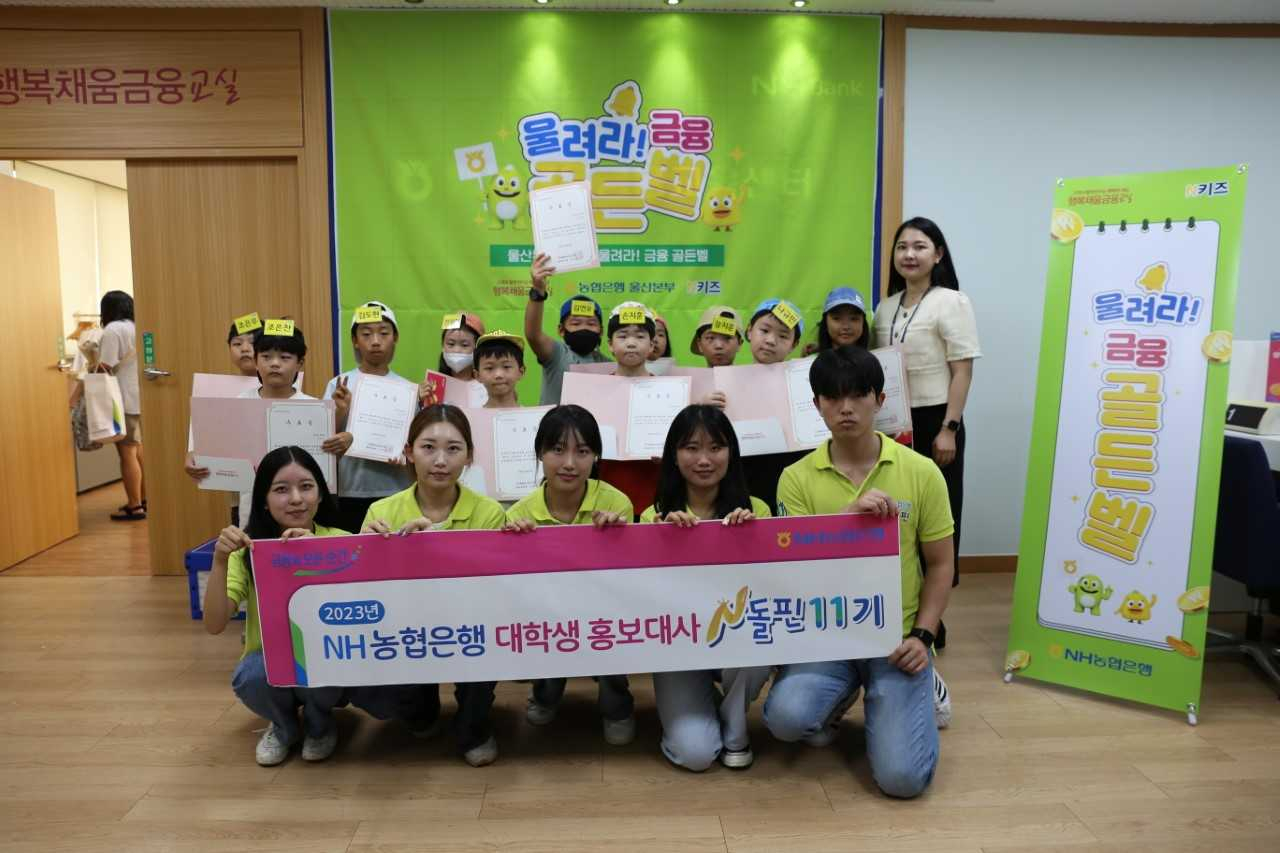 23일 NH농협은행 울산본부의 ‘N키즈 금융학교’에 참여한 대학생봉사단 N돌핀 11기와 초등학생들이 기념촬영을 하고 있다. [사진=NH농협 울산본부]