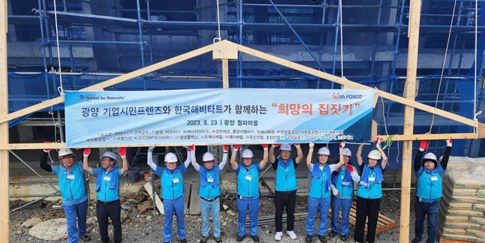포스코 기업시민프렌즈가 광양 월파마을 해비타트 공동주택 건설현장 앞에서 봉사활동 기념 촬영을 하고 있다.