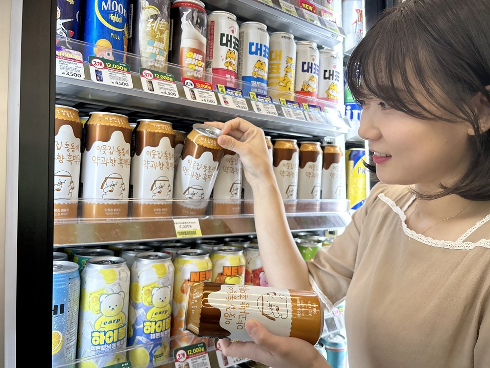 모델이 CU의 차별화 맥주 상품 ‘이웃집 통통이 약과향 흑맥주’를 집어들고 있다. [BGF리테일 제공]