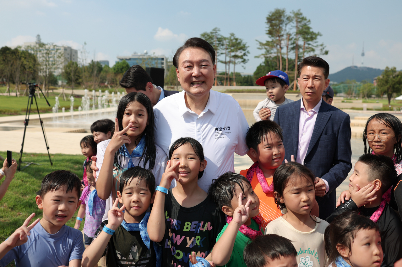 윤석열 대통령이 26일 서울 용산어린이정원 내 조성된 분수정원에서 열린 다둥이가족 초청행사에 깜짝 방문, 어린이들과 기념사진을 찍고 있다. [연합]