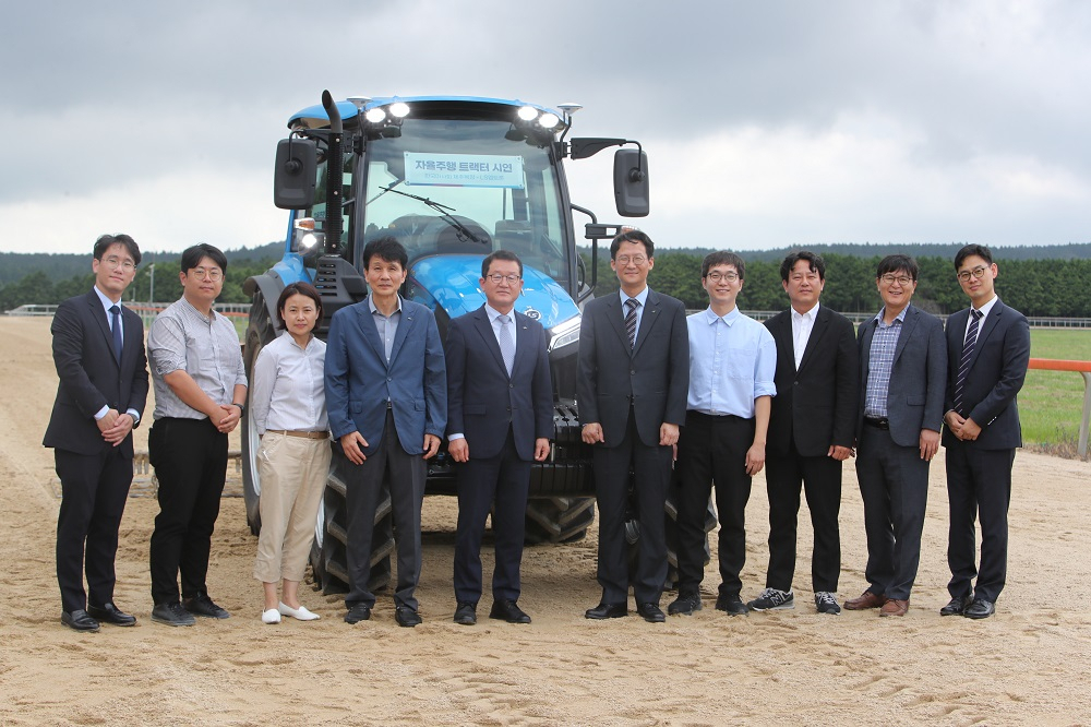 LS엠트론 임직원들과 한국마사회 관계자들이 자율주행 트랙터 앞에서 기념사진을 촬영하고 있다. [LS엠트론 제공]