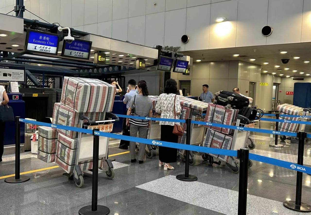 North Koreans line up at a check-in counter for Air Koryo, North Korea's national carrier, at Beijing Capital International Airport on Aug. 22. (Yonhap)