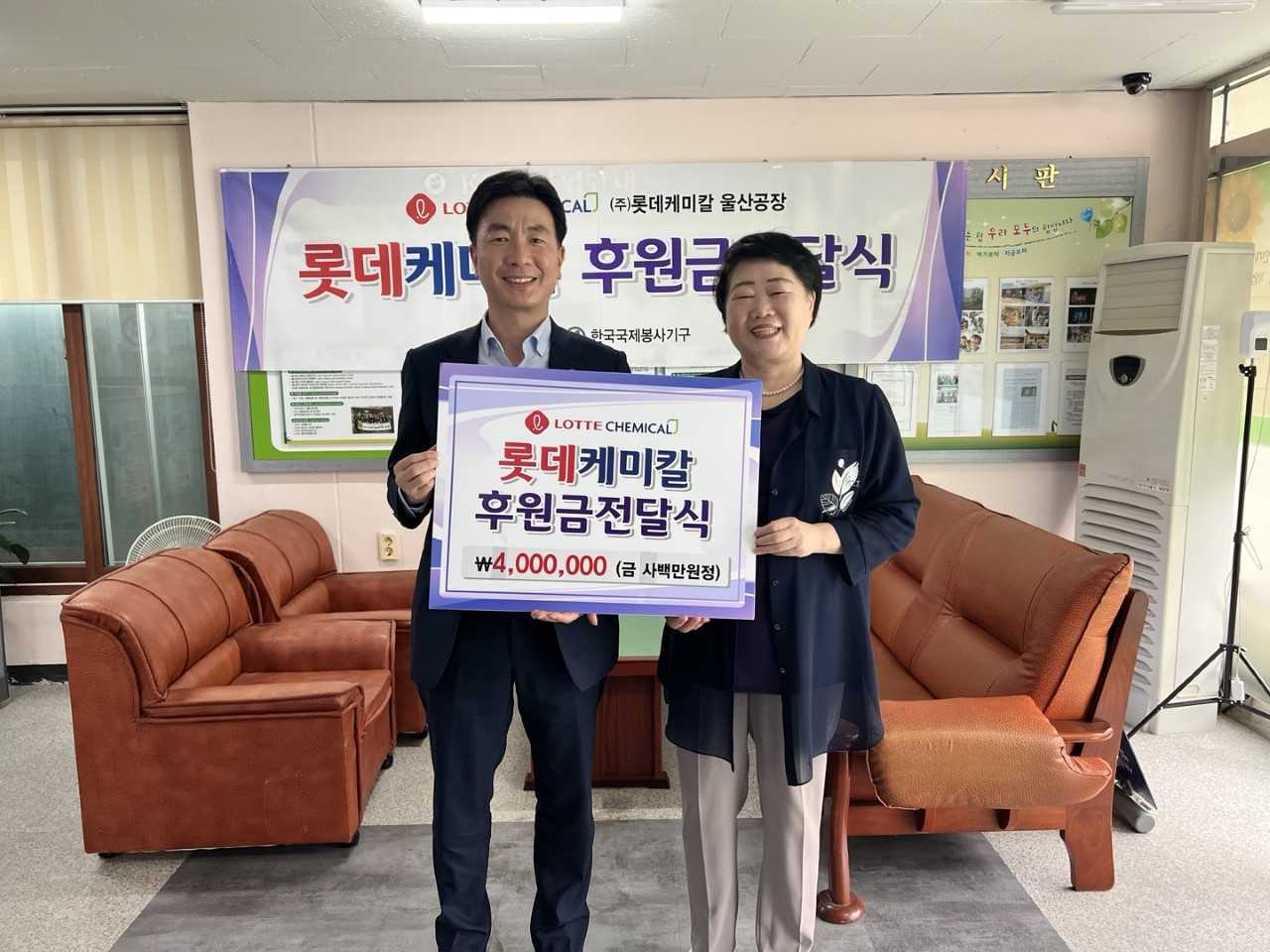 롯데케미칼 울산공장 관계자가 28일 오전 한국국제봉사기구에 독거노인 지원금 400만원을 전달하고 있다. [사진=롯데케미칼 울산공장]