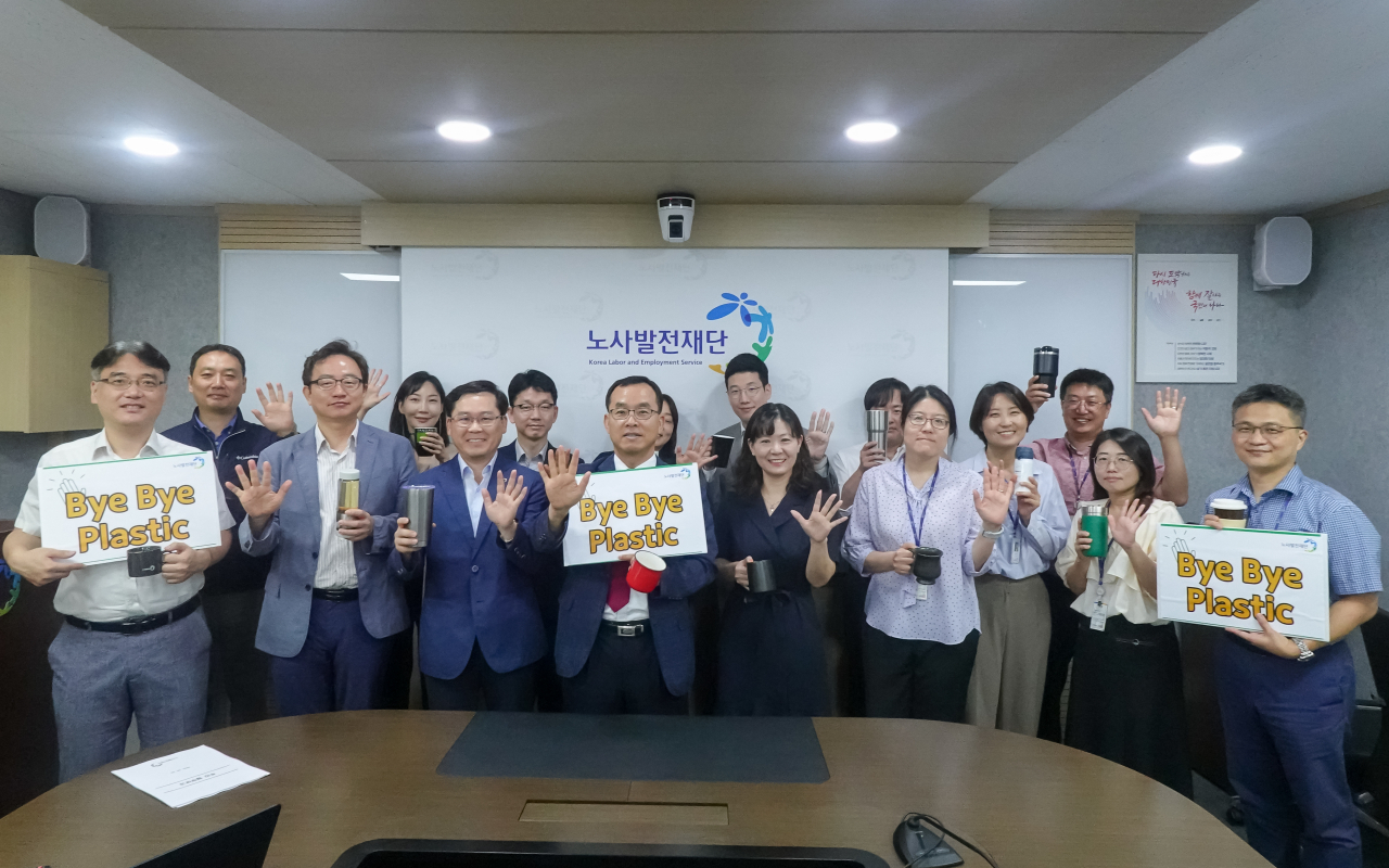 김대환 노사발전재단 사무총장(가운데)과 임직원이 '바이바이 플라스틱 챌린지'를 진행하며 기념사진을 촬영하고 있다. [노사발전재단 제공]