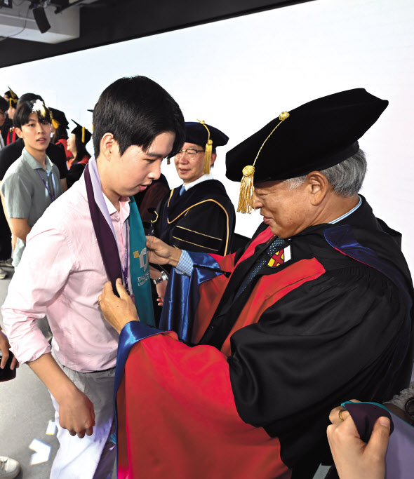 30일 서울 종로구 태재대학교에서 염재호(오른쪽) 총장이 신입생들의 목에 학교의 상징이 담긴 스톨(어깨 덮개)을 걸어주고 있다. 태재대학교는 한샘 창업주인 조창걸 명예회장이 사재 3000억원을 들여 설립했으며 이날 첫 신입생들이 입학했다. 임세준 기자