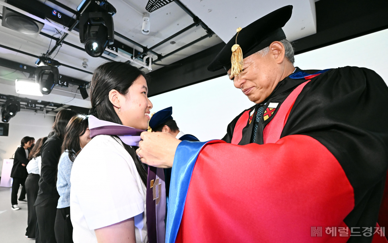 30일 서울 종로구 태재대학교에서 입학식이 열려 염재호 총장이 신입생 전다희 양에게 기념 스톨을 목에 걸어주고 있다. 태재대학교는 조창걸 한샘 창업주가 사재 3000억원을 들여 설립했으며 이날 첫 신입생들이 입학했다. 임세준 기자