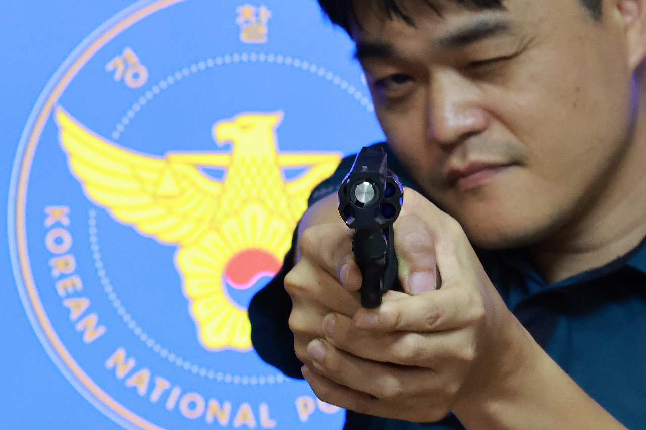 경찰 관계자가 29일 서울 서대문구 경찰청에서 저위험 권총을 공개하고 있다. 정부가 29일 발표한 2024년 예산안에 따르면 경찰관 3명당 1정씩 지급됐던 저위험 권총을 한명에 1정씩 지급하기로 하는 데 86억원이 쓰인다. 지난해 도입한 저위험 권총은 살상용인 38구경 권총에 비해 무게가 가볍고 안전장치도 달려있다. [연합]