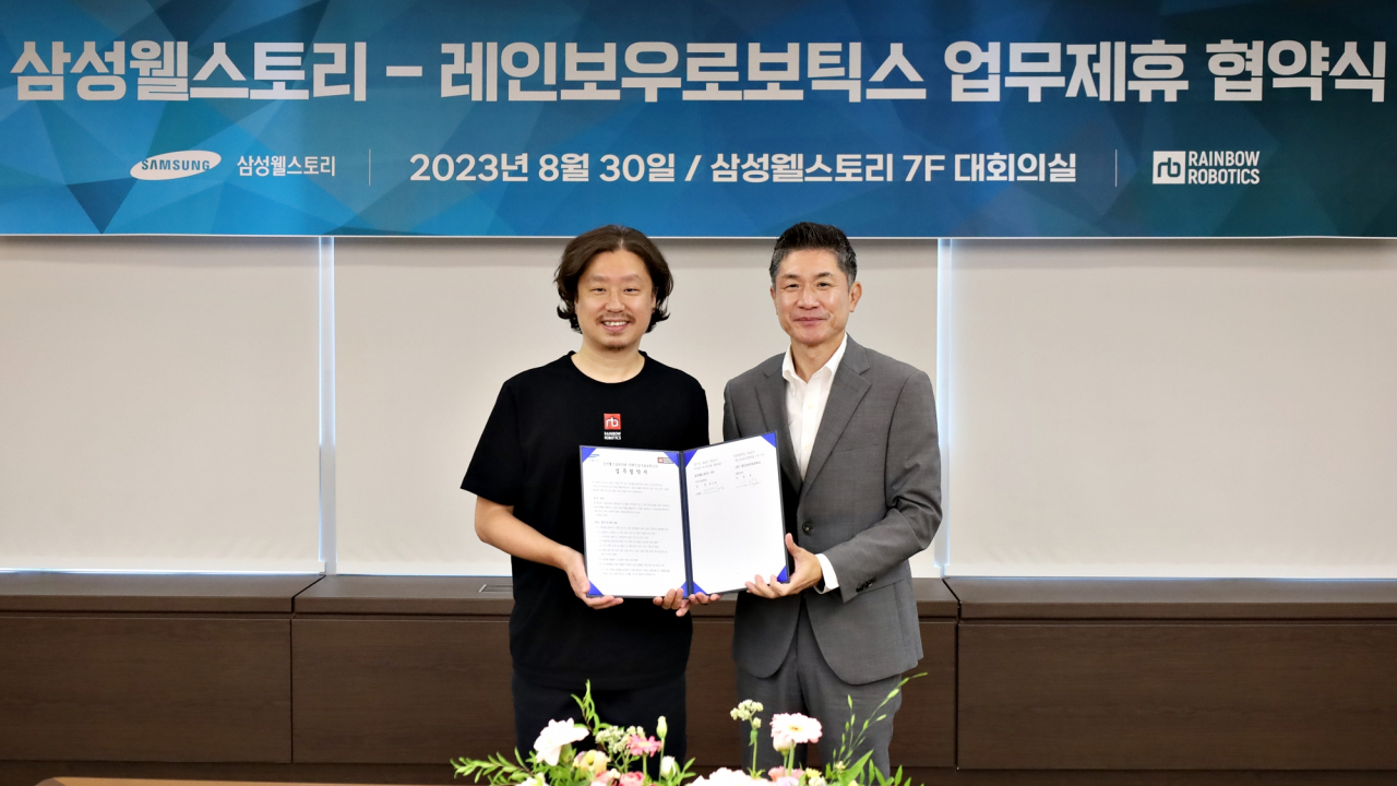 김헌(오른쪽) 삼성웰스토리 FSC사업부장과 이정호 레인보우로보틱스 대표가 단체급식에 로봇 자동화 솔루션을 도입하기 위한 업무제휴 협약식에 참석해 기념촬영을 하고 있다.[삼성웰스토리 제공]