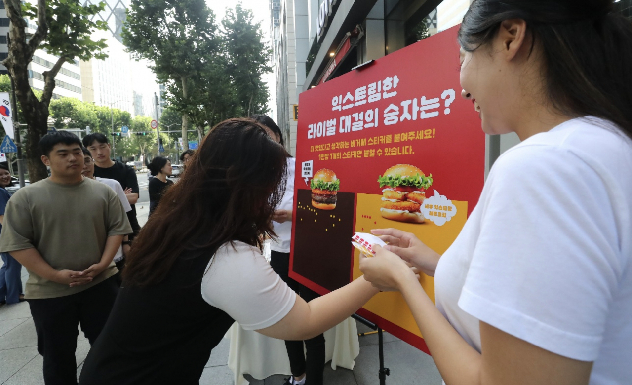 17일 서울 강남구 롯데리아 선릉점에서 진행한 롯데리아 대표버거 라이벌전 시식회에 참여한 사람들이 투표를 하고 있다. [롯데GRS 제공]