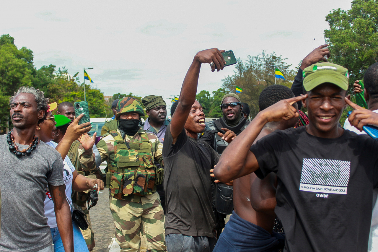 People pose with soldiers as they celebrate in support of the putschists in a street of Libreville, Gabon. (Reuters-Yonhap)