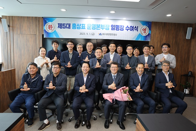 여수광양항만공사 홍상표 신임 운영본부장이 꽃다발을 든 채 축하를 받고 있다.