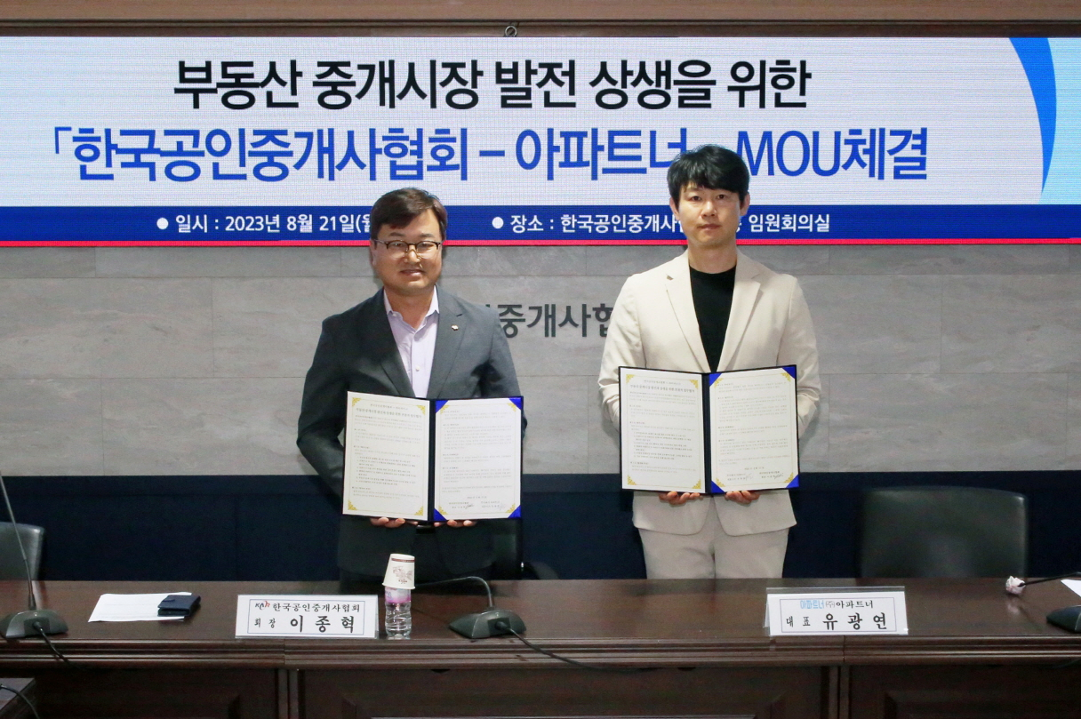 지난달 21일 열린 업무협약식에서 이종혁 한국공인중개사 협회장(왼쪽)과 유광연 아파트너 대표가 사진 촬영을 위해 협약서를 들고 있다. [한국공인중개사협회]
