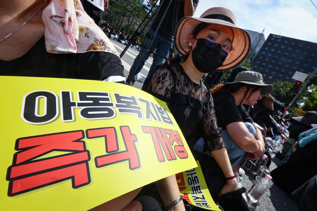 교사들이 2일 오후 서울 영등포구 국회대로에서 열린 '50만 교원 총궐기 추모 집회'에서 팻말을 들고 있다. [연합]
