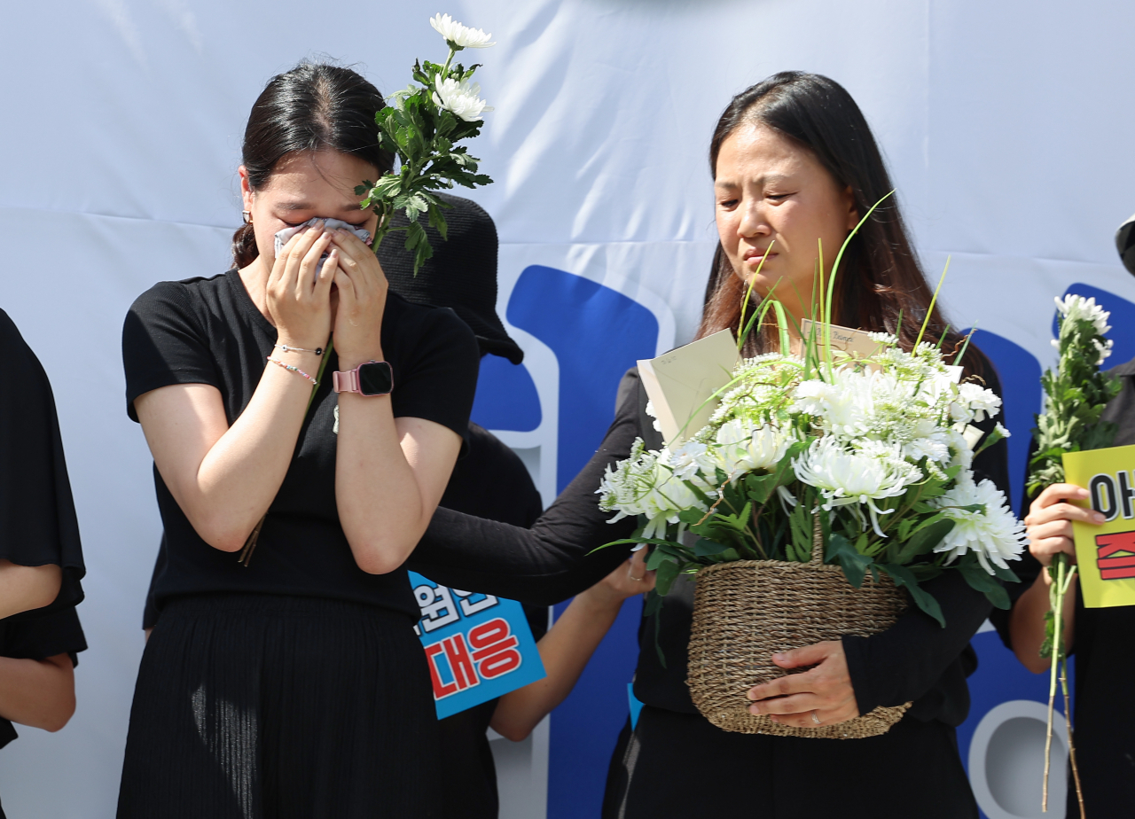 지난 2일 오후 서울 영등포구 국회대로에서 열린 '50만 교원 총궐기 추모 집회'에서 지난 7월 숨진 서이초 교사의 대학원 동기들이 눈물을 흘리고 있다. [연합뉴스]