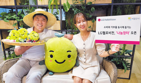 LG헬로비전 관계자가 ‘나눔장터’안내 문구와 해피빈 마스코트를 들고 있다. [LG헬로비전 제공]