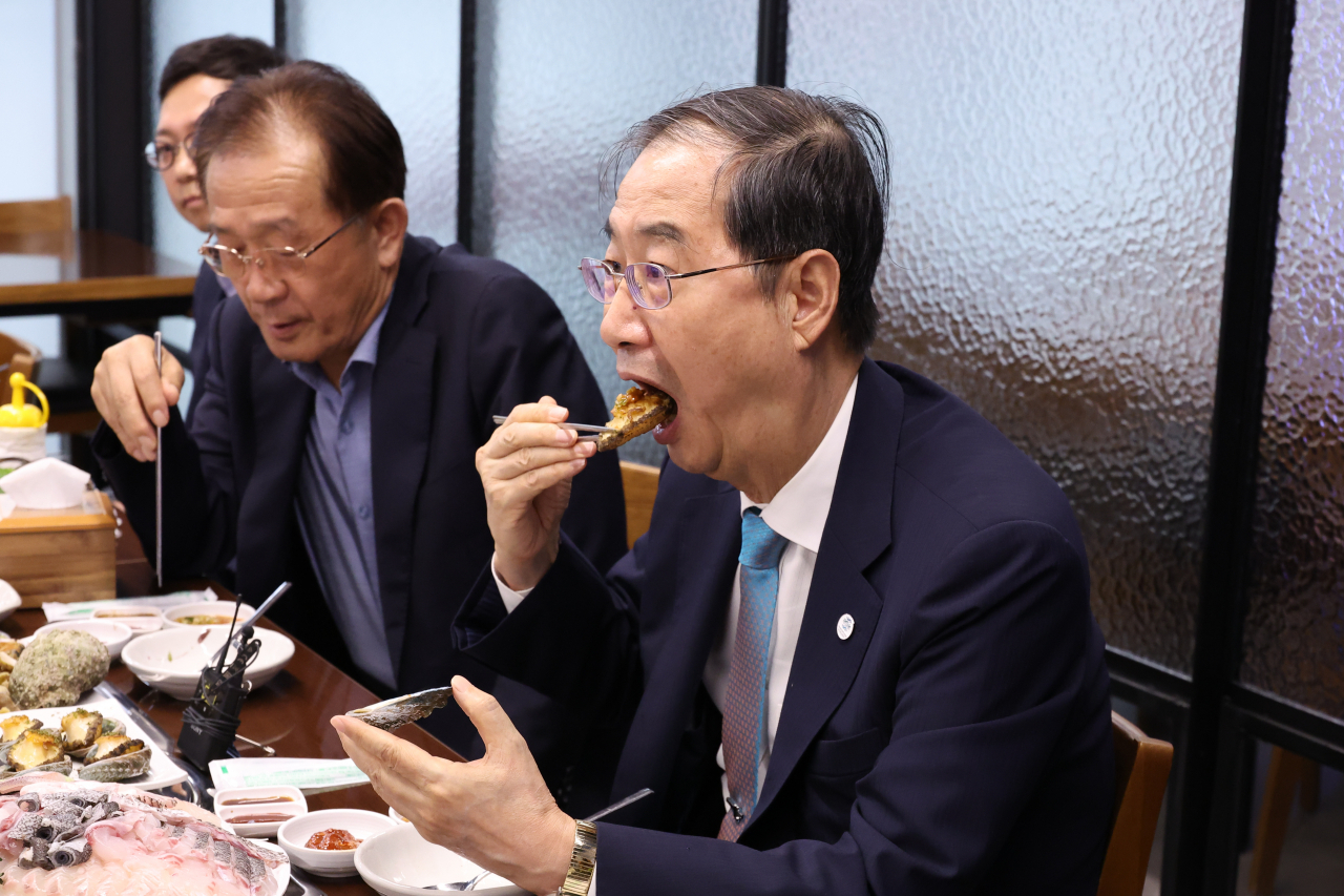 한덕수 국무총리가 4일 오후 서울 송파구 가락몰 내 수산물 시장을 찾아 직접 구입한 수산물로 만든 음식으로 저녁 식사를 하고 있다. [연합]