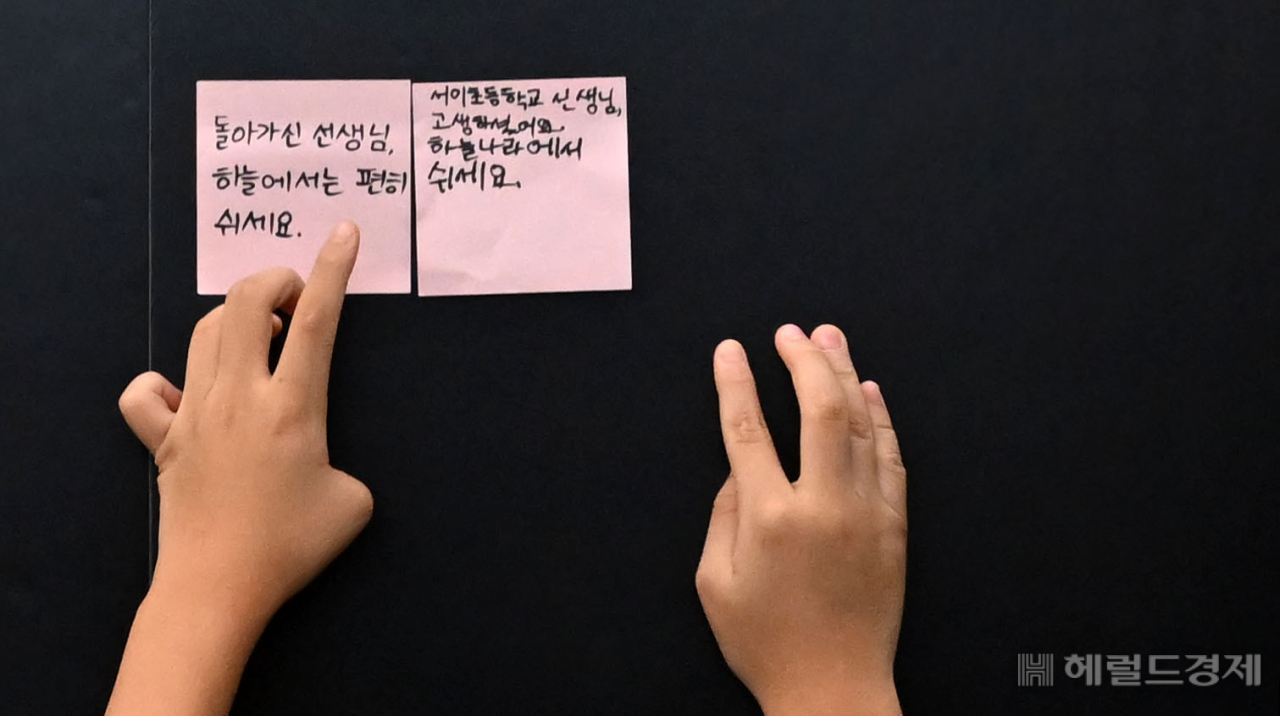 사망한 서이초 교사의 49재일인 4일 오전 한 학생이 서울 서초구 서이초등학교 마련된 추모공간에 추모글을 붙이고 있다 . 이상섭 기자
