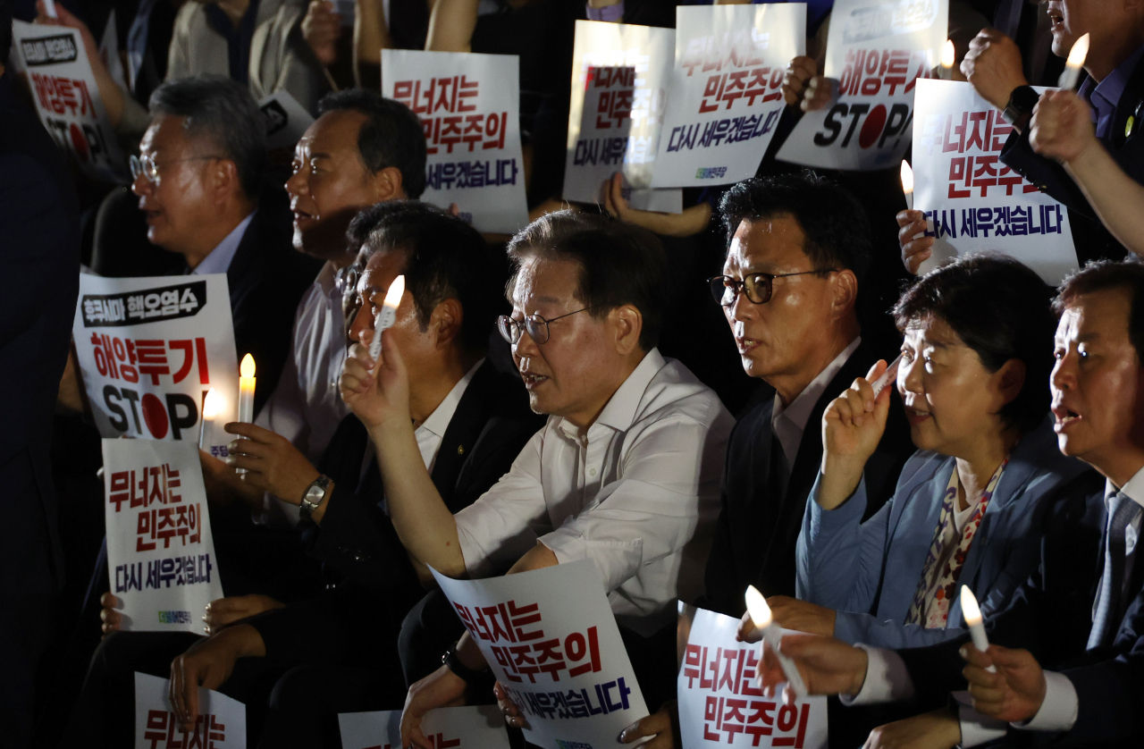 이재명 더불어민주당 대표와 박광온 원내대표 등이 4일 국회 앞 계단에서 열린 민주주의 회복 촛불문화제에 참가하고 있다. [연합]