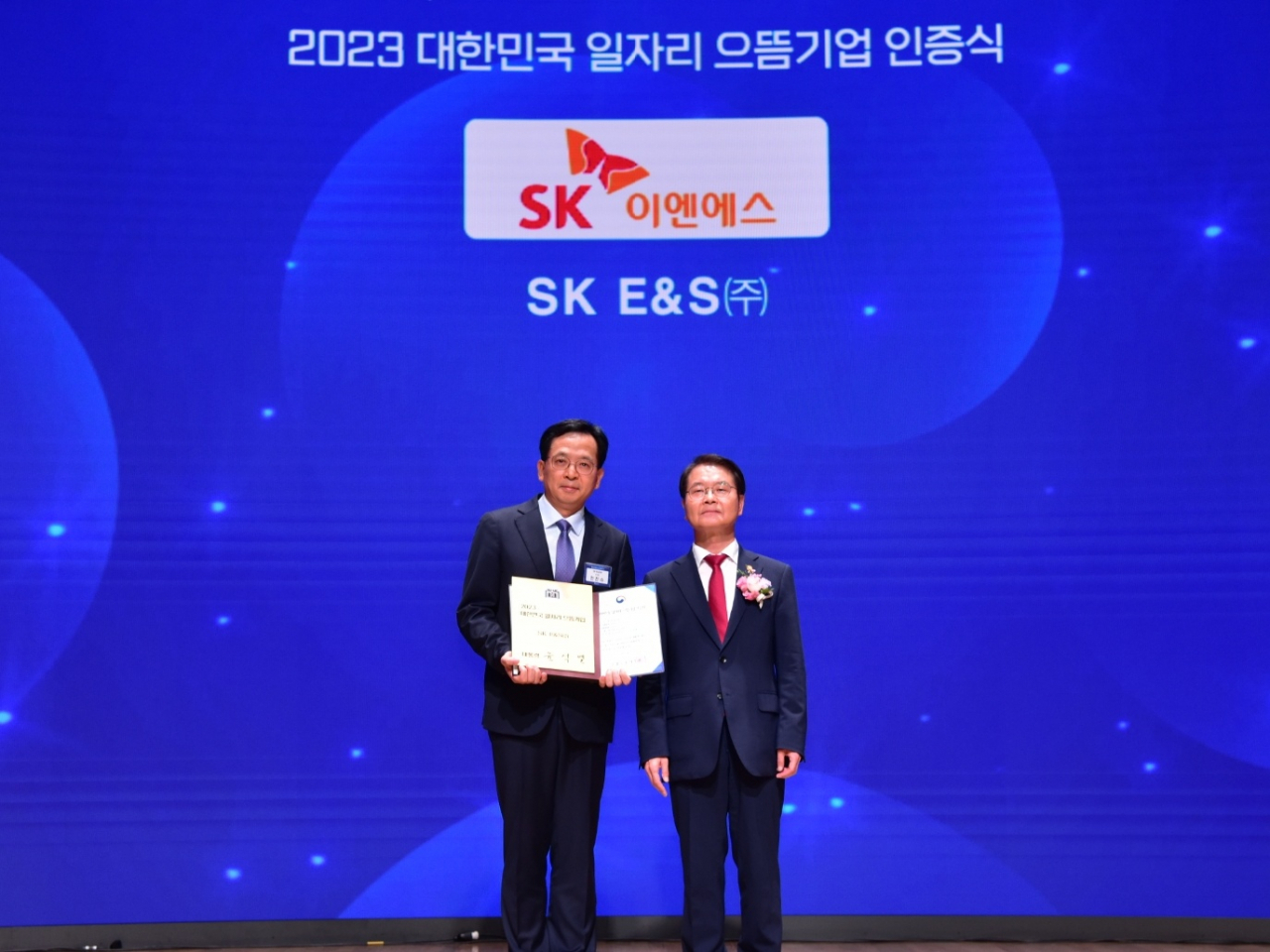 이정식(오른쪽) 고용노동부 장관이 지난 4일 서울 중구 대한상공회의소에서 열린 ‘2023 대한민국 일자리 으뜸기업’ 시상식에서 안진수 SK E&S 부사장에게 대통령 인증패를 수여한 후 기념촬영을 하고 있다. [SK E&S 제공]