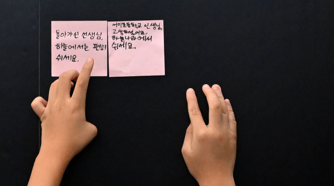 사망한 서이초 교사의 49재일인 4일 오전 한 학생이 서울 서초구 서이초등학교 마련된 추모공간에 추모글을 붙이고 있다 . 이상섭 기자