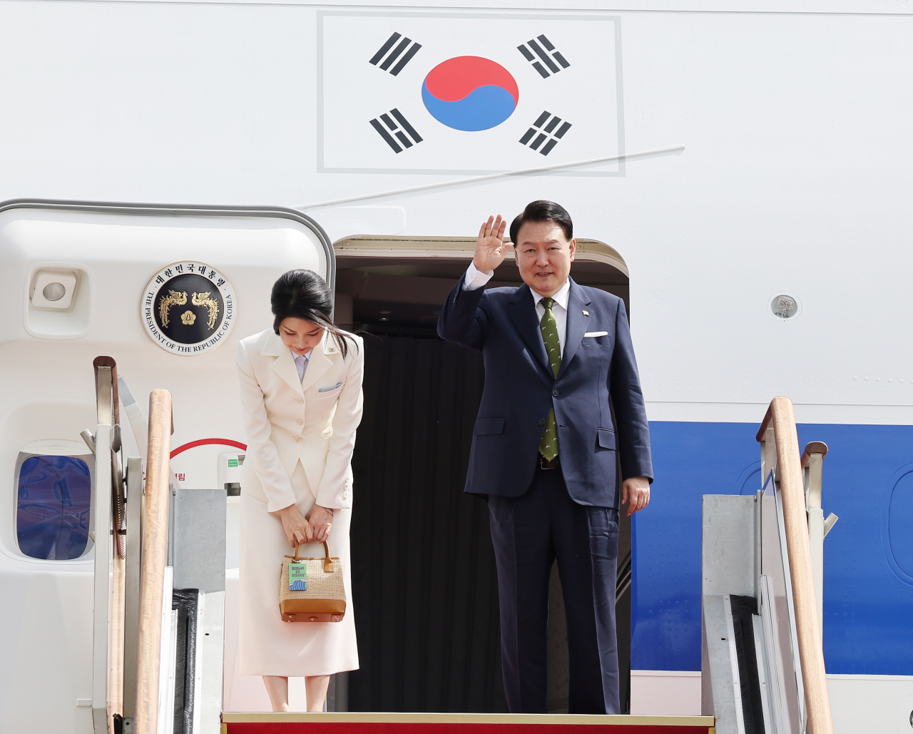 아세안(ASEAN·동남아시아국가연합) 관련 정상회의와 주요 20개국(G20) 정상회의 참석 등을 위해 인도네시아와 인도를 순방하는 윤석열 대통령과 부인 김건희 여사가 5일 성남 서울공항에서 출국하며 전용기인 공군 1호기에 올라 환송객을 향해 손을 흔들고 있다. [연합]