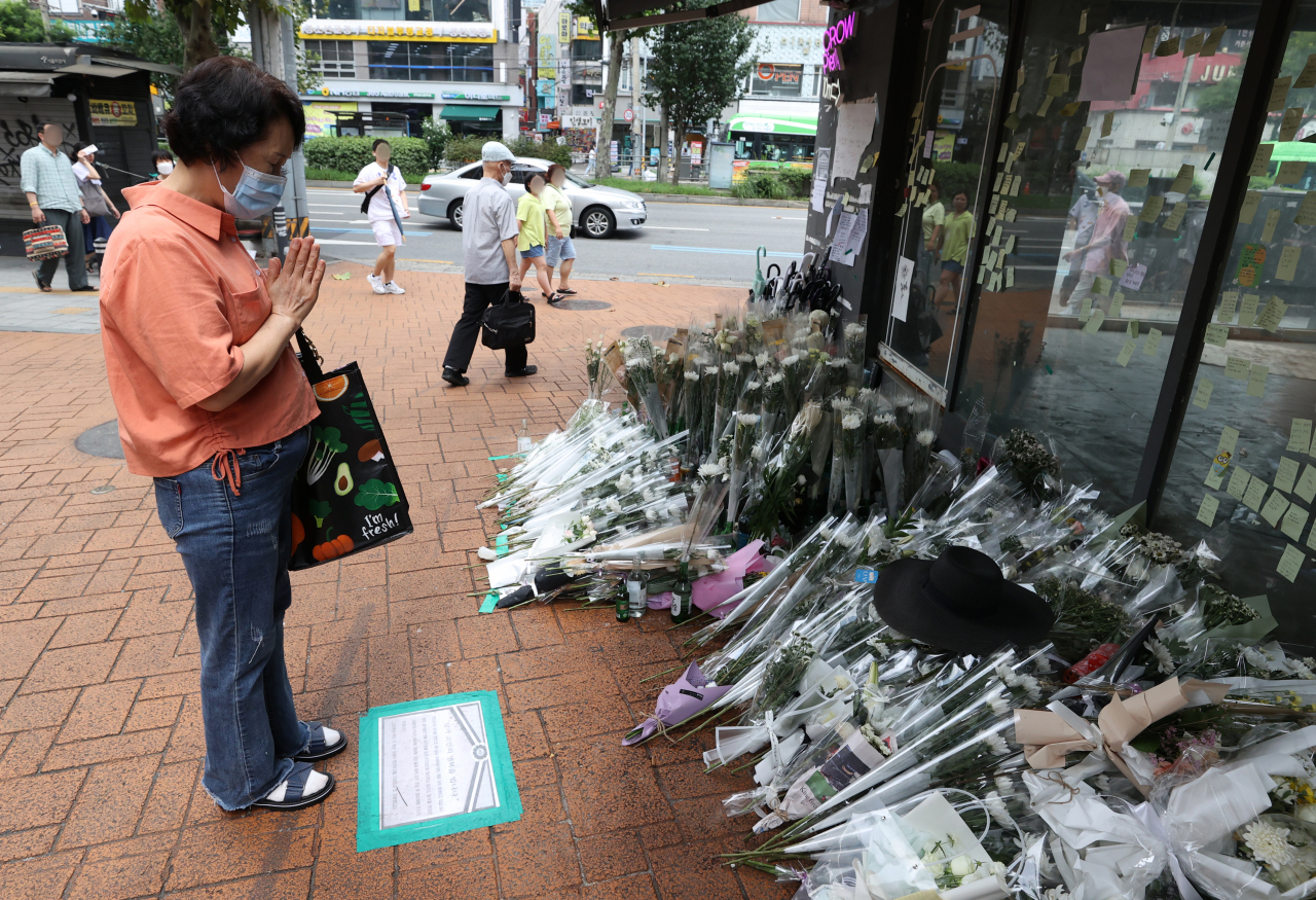 서울 관악구 신림역 인근 상가 골목에 마련된 흉기난동 사건으로 숨진 20대 남성 피해자 A씨를 위한 추모 공간에서 한 시민이 기도하고 있다. 한편 행인에게 흉기를 휘둘러 4명의 사상자를 낸 조모 씨에 대한 신상 공개 여부는 오는 26일 결정된다. [연합]