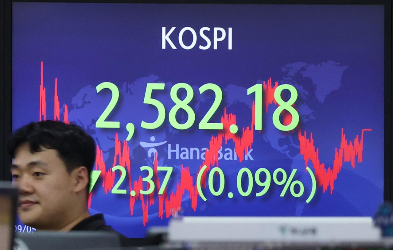 5일 오후 서울 중구 하나은행 딜링룸에서 직원이 전광판 앞을 지나고 있다. 이날 코스피는 전장보다 2.37포인트(0.09%) 하락한 2582.18로, 코스닥지수는 전장보다 2.32포인트(0.25%) 오른 921.48로 마쳤다.서울 외환시장에서 달러 대비 원화 환율은 전날보다 10.8원 상승한 1330.60원에 마감했다. [연합]