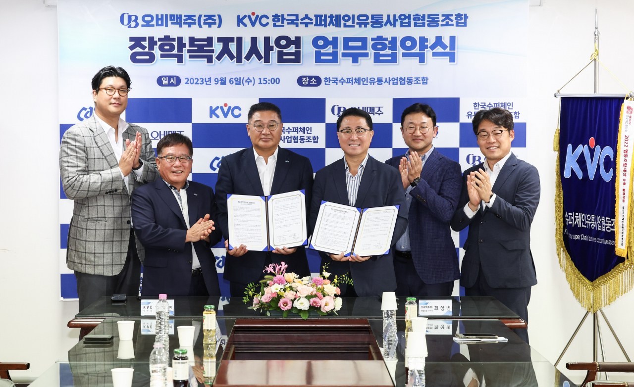 김재면(왼쪽 세번째) 한국수퍼체인유통사업협동조합 이사장과 최상범(왼쪽 네번째) 오비맥주 영업총괄부사장이 ‘대‧중소기업 상생을 위한 장학복지사업’ 업무협약을 체결했다. [중기중앙회 제공]