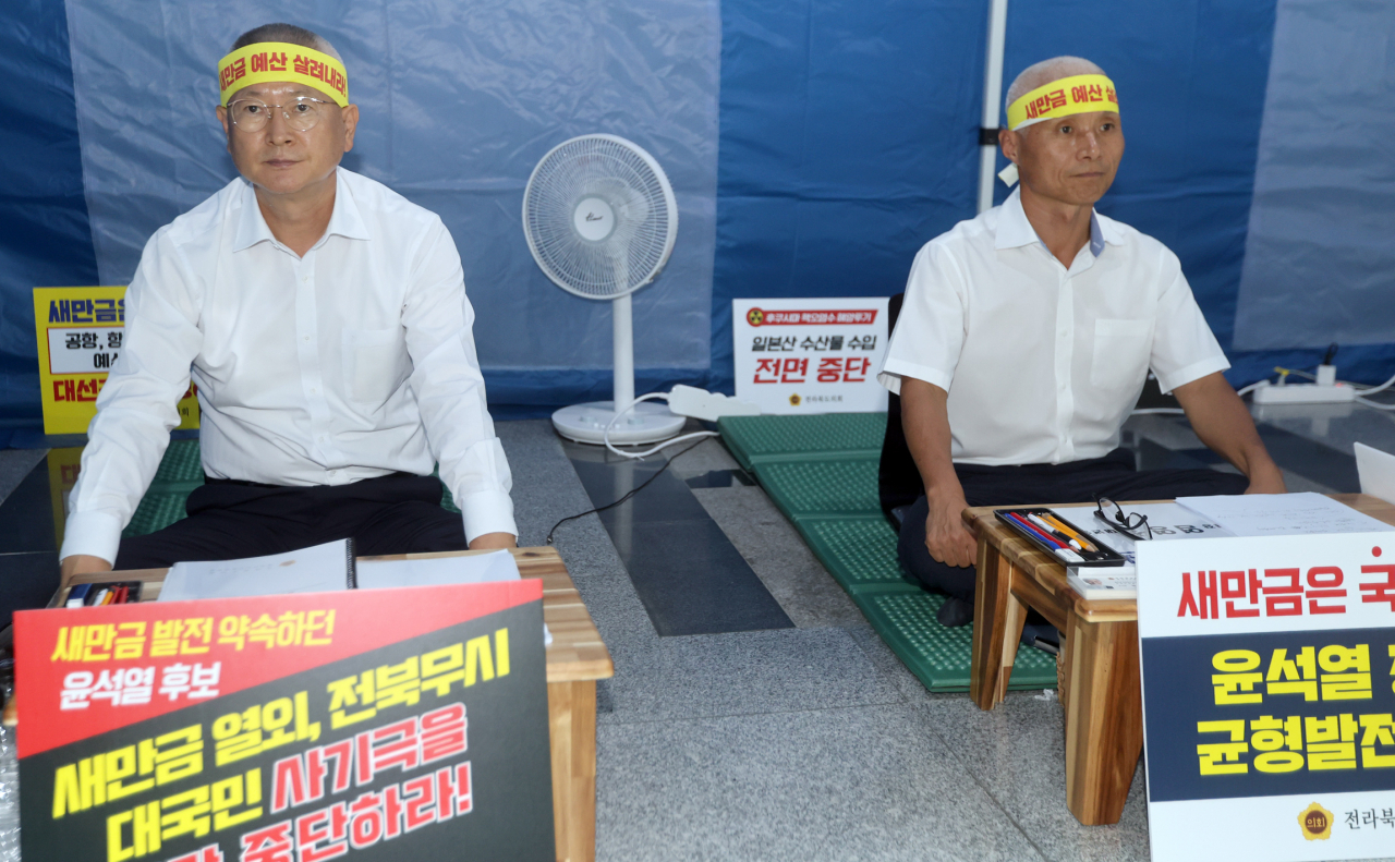전북도의회 김정수 운영위원장(왼쪽)과 염영선 대변인이 6일 전북도의회 청사 로비에서 이틀째 단식 투쟁을 벌이고 있다. 이들은 "새만금 사업 관련 예산 78% 삭감은 상식적으로 납득할 수 없는 예산폭력"이라며 "이번 사태에 대한 도민의 분노를 표출하고자 삭발과 단식 투쟁에 나선다"고 밝혔다. 전북도의원들은 릴레이로 사흘간 단식 투쟁에 나선다.[연합]