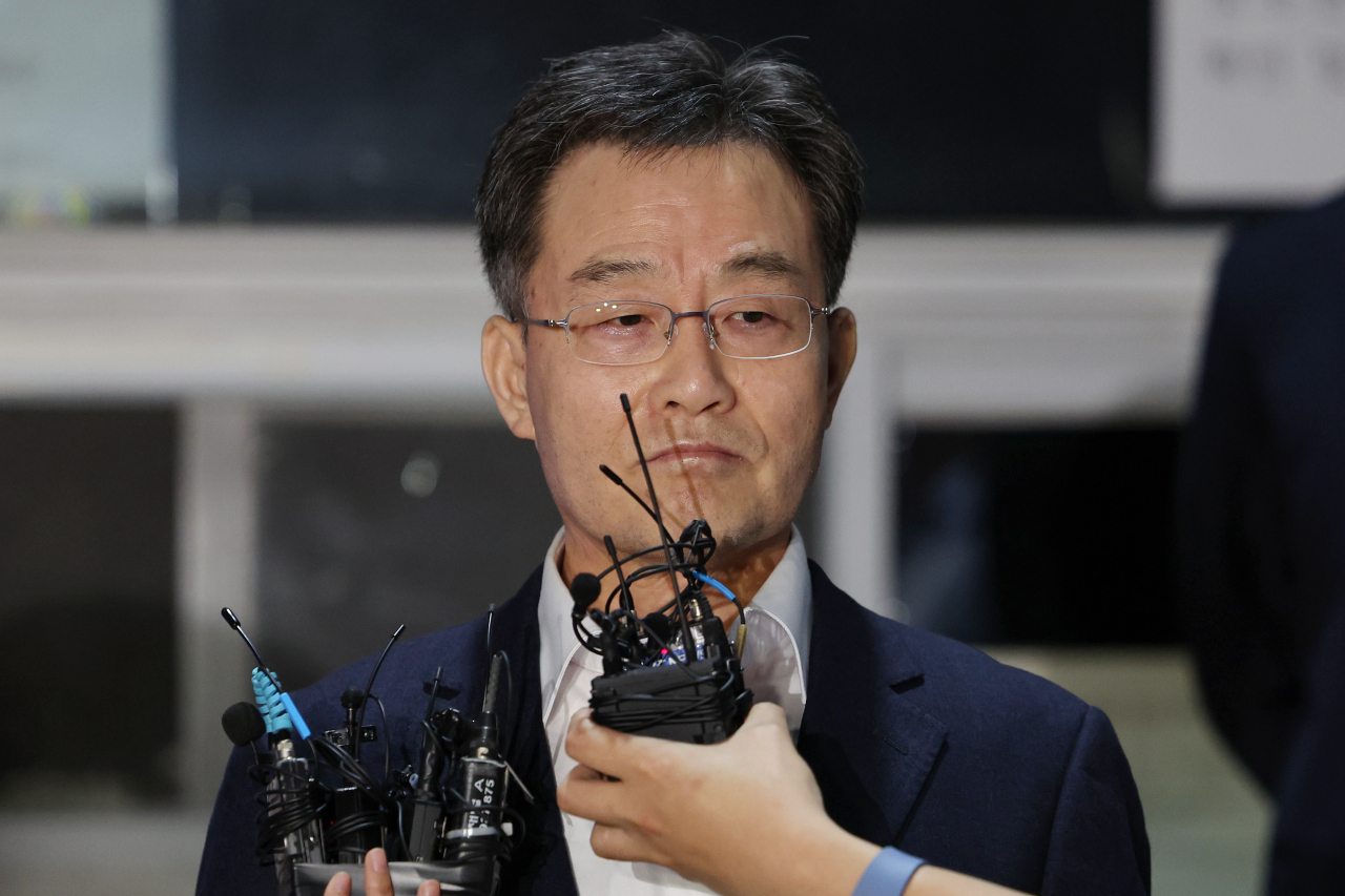 화천대유자산관리 대주주 김만배 씨가 7일 오전 구속기간 만료로 석방돼 서울구치소에서 나와 취재진 질문을 듣고 있다. 앞서 검찰은 김씨의 구속기한이 임박하자 횡령, 이해충돌방지법 위반 등 혐의로 구속영장을 추가 발부해달라고 재판부에 요청했으나 법원이 이를 받아들이지 않았다. 대장동 사건과 관련해 김씨가 구속됐다가 풀려난 것은 이번이 두 번째다. [연합]