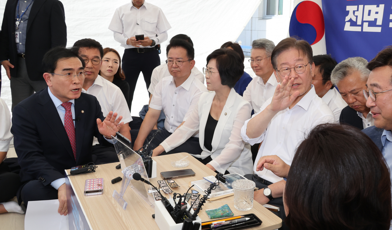더불어민주당 이재명 대표가 단식 투쟁 중인 국회 앞 천막에서 국민의힘 태영호 의원을 만나고 있다. 이 대표가 퇴장을 요구하는 당직자들에게 그만하라는 손짓을 하고 있다. 태 의원은 본회의장 야당 의원들의 발언에 항의하기 위해 이재명 대표를 찾았다. 연합뉴스