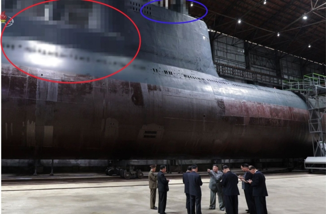 2019년 7월 북한 조선중앙TV가 공개한 잠수함 모습. 서 SLBM 발사관이 위치했을 것으로 추정되는 부분(붉은 원)과, 함교탑 위 레이더와 잠망경 등이 위치했을 것으로 추정되는 부분(파란 원) [조선중앙TV]